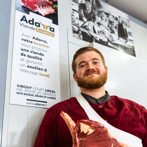 Un boucher montre une pièce de boeuf coupée par la boucherie Sarthou à Lons