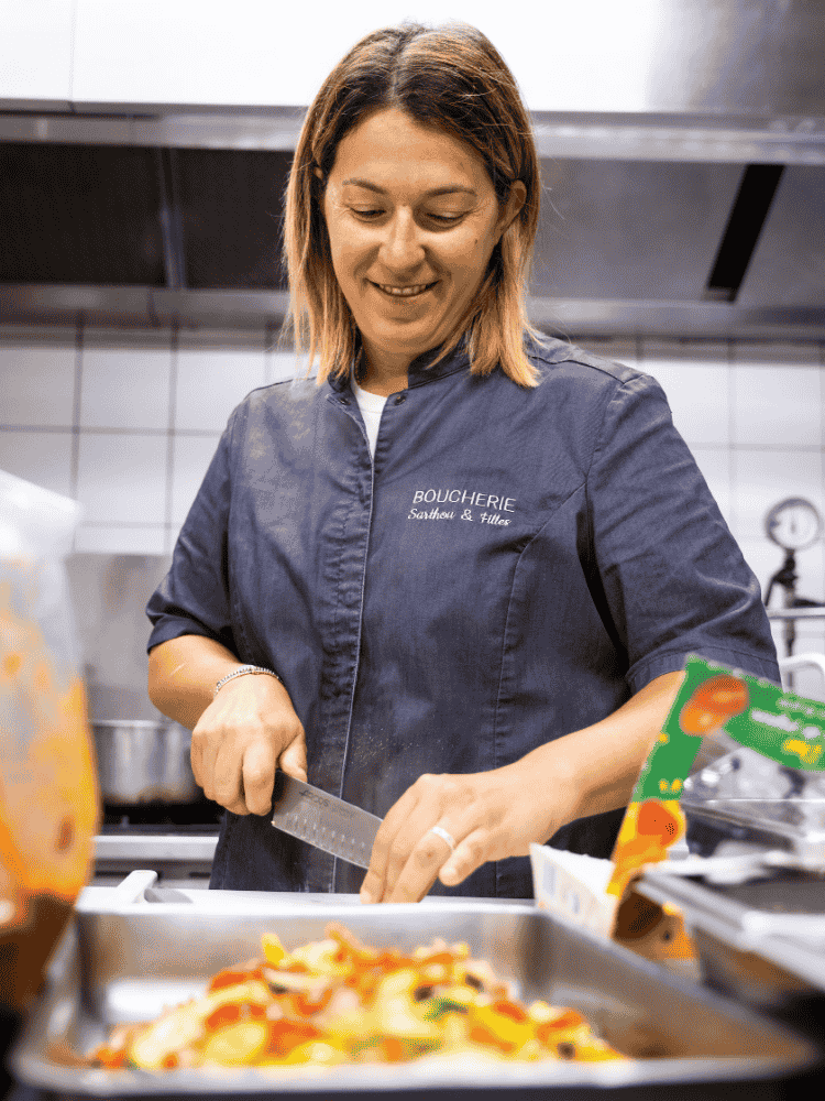 l'une des gérantes de la boucherie Sarthou prépare un plat cuisiné à Lons pour le service traiteur